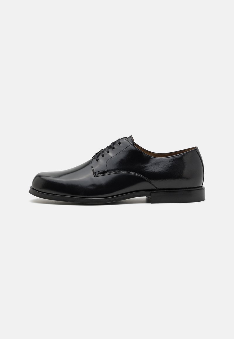 Chaussure habillée en cuir noir avec une finition lisse et polie, bout rond, design classique à lacets et un petit talon.