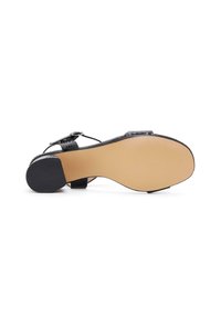 Zwarte hak sandaal met een gestructureerde bovenkant, voorzien van een verstelbare band en een stevige, gladde beige zool met een rubberen basis voor grip.