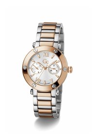 Ezüst és rozéarany színű fém óra kerek tokal, texturált fehér számlappal, római számokkal és két szubdialal, láncos karkötőn.