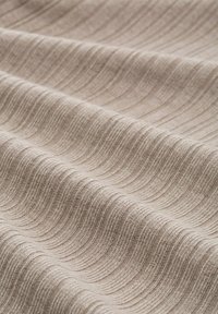 Strukturiertes Gewebe in Beige mit einem subtilen Wellenmuster, das weiche, gewebte Garnen und glatte Linien zeigt, die Tiefe und Dimension erzeugen.