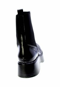 Stivale nero lucido alla caviglia con tacco spesso, linguetta posteriore e pannelli laterali elastici, fotografato da dietro su uno sfondo bianco.