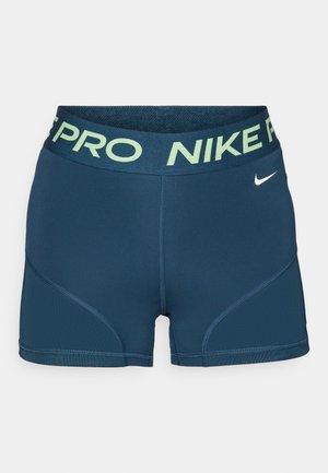 Tumesinise Nike Pro kompressioonipingutused, millel on heleda rohelise logo jaotla ning sile ja veniv kangas. Omab paneelide detailide esitlust külgedel.