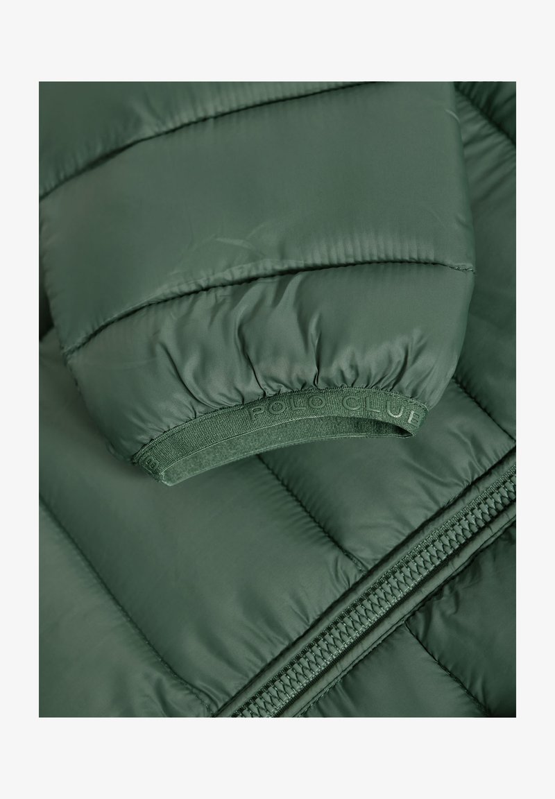 Padded grüne Jacke mit geripptem Ärmelsaum, gebrandetem elastischem Band und seitlichem Reißverschluss. Das Material wirkt glatt mit einem leichten Glanz.