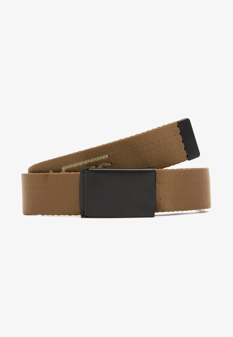 Ceinture en tissu marron avec une boucle métallique rectangulaire noire, partiellement enroulée et posée à plat sur un fond blanc.