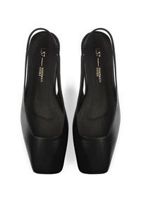 Zapatos de tacón negro tipo slingback con un acabado de cuero suave, punta afilada y una suela media ancha. Presenta un diseño minimalista con una sutil marca en el interior.