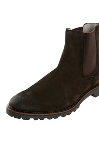 Braune Wildleder-Ankle-Boots mit elastischen Seiteneinsätzen und einer strukturierten Gummisohle. Mit einer abgerundeten Zehenpartie und kontrastierenden braunen Nähten.