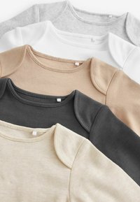 Four short-sleeve tops displayed in a stack. Colors include black, beige, gray, and white. Notable soft cotton texture and rounded necklines.