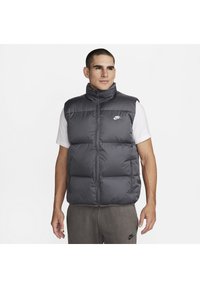 Gilet imbottito grigio con colletto alto, compartimenti imbottiti, zip frontale e tasche laterali. Presenta un piccolo logo bianco Nike sul petto.