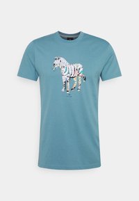 Modré tričko s krátkým rukávem s barevným vzorovaným zebra grafickým motivem umístěným uprostřed hrudi a malým textem "PS Paul Smith" pod ním.