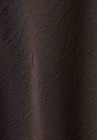 Tela marrón texturizada con una superficie arrugada; presenta un patrón de diamantes y un acabado ligeramente brillante. Material ligero y flexible.