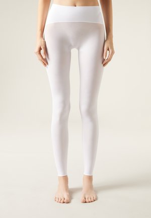 Hvide leggings med høj talje, glat tekstur og strækbart materiale, designet til at sidde tæt fra talje til ankel.