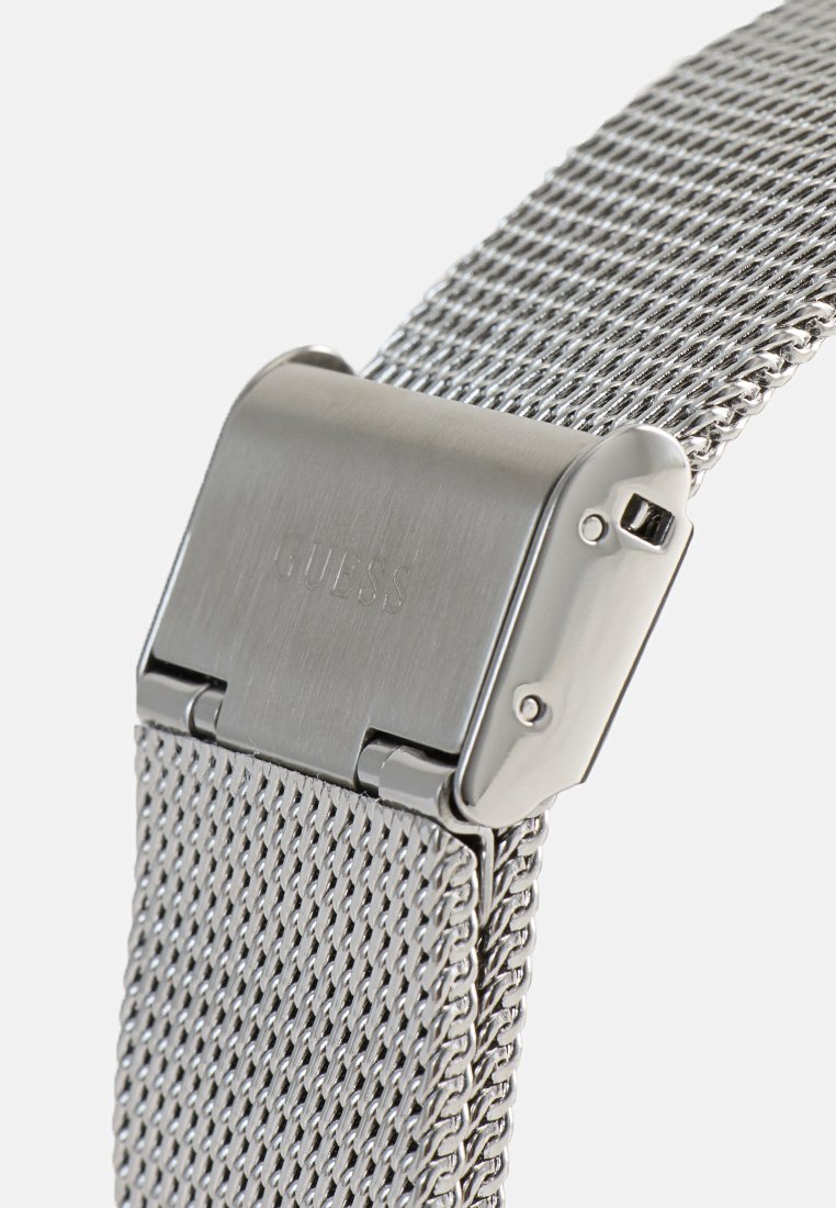 Correa de reloj de malla de acero inoxidable con una hebilla plateada pulida que presenta el nombre de la marca grabado. Superficie texturizada con enlaces entrelazados.