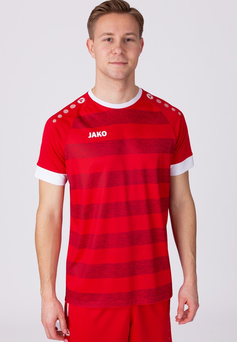Rotes Sportshirt mit horizontalen Streifen, weißen Akzenten am Kragen und an den Ärmeln sowie dem Logo "JAKO" auf der Vorderseite. Mit abgesetzten Schulterpunkten.