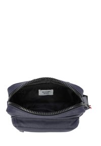 Sacchetto in tessuto blu navy con chiusura a zip, foderato internamente di nero, e etichetta "JOOP! JEANS" visibile. Design compatto con una texture liscia.