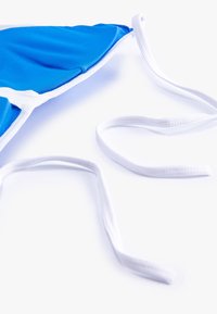 Blauwe bikini-top met een driehoekige vorm, voorzien van witte accenten en verstelbare strikken. Gladde textuur en rekbaar materiaal voor comfort.