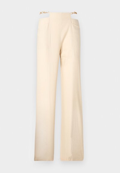 Platas kājas bikses krēmkrāsā ar gludu tekstūru, kurām ir augsts jostasvieta un zelta ķēdes akcenti jostasvietā.