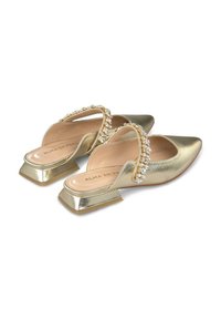 Zapatos de slingback metálicos dorados con punta afilada, que incluyen una tira adornada con cristales y un tacón cuadrado bajo y elegante.
