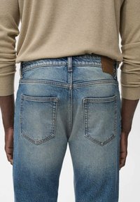 Lichtblauwe denim jeans met een vervaagd resultaat, voorzien van een klassieke vijf-pocketontwerp, leren patch op de taille en contrasterende stiksels.