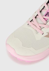 Lett og atletisk sko med en teksturert beige overdel, rosa detaljer og gummisåle. Har et mønstrete design og snøringssystem.
