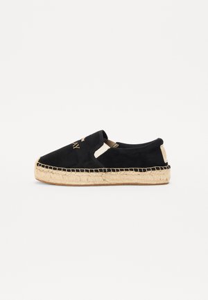 Fekete velúr slip-on cipők természetes jutaszólappal, varrásokkal ellátva és textúrázott felsőrésszel. Elöl logóval kiemelve.