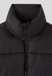 Giacca piumino nera con colletto alto, zip frontale e texture trapuntata. Presenta un tessuto morbido e nessun dettaglio hardware visibile.