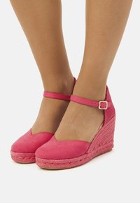Sandali espadrilles con tacco a zeppa in suede rosa, con cinturino alla caviglia, dotati di una suola intermedia in juta intrecciata e design a punta tonda.