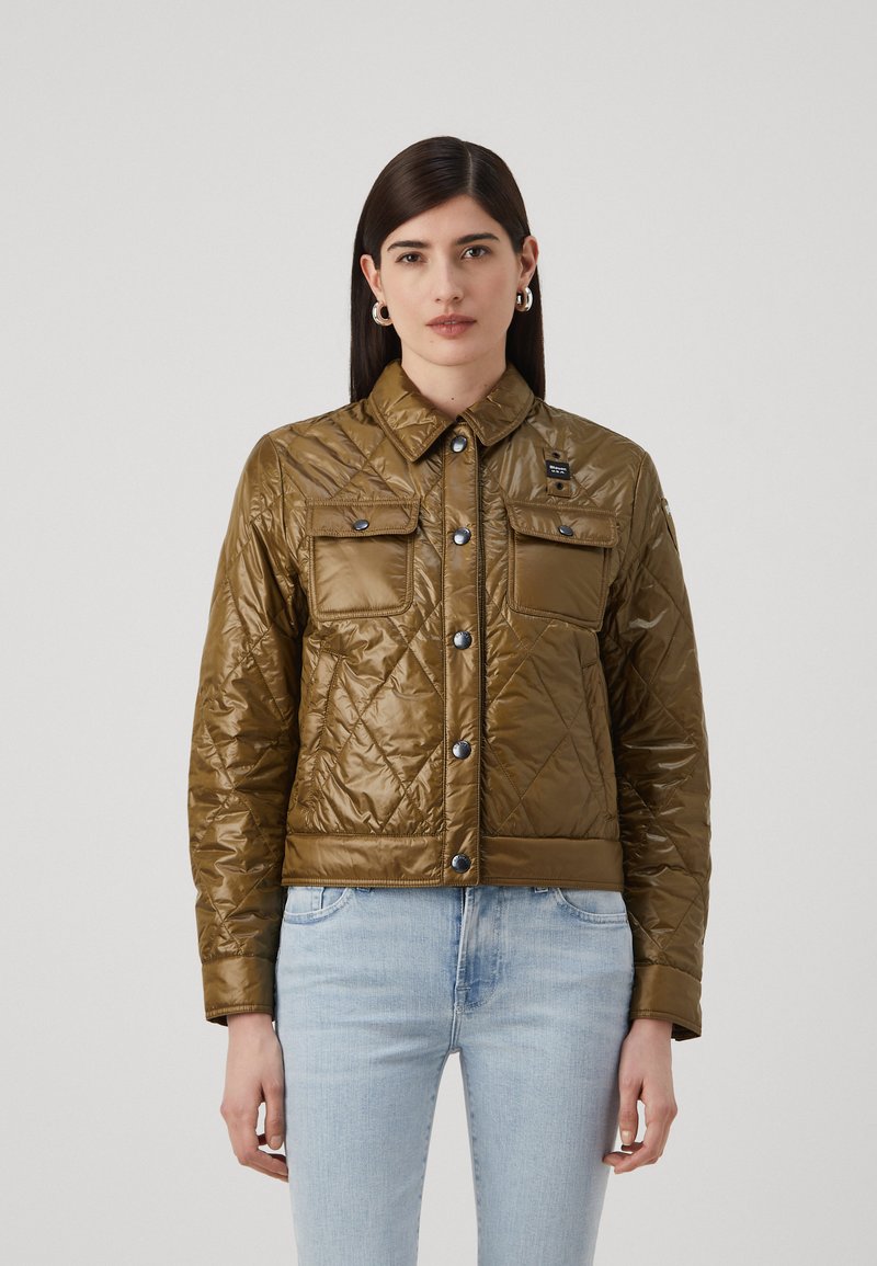 Giacca trapuntata verde oliva con colletto, due tasche sul petto e bottoni a pressione; presenta una texture liscia e lucida.