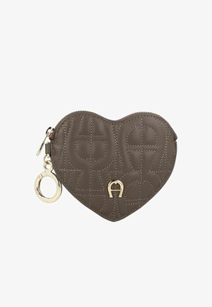 Bruine lederen pouch in hartvorm met een reliëf logo patroon, gouden hardware en een ritssluiting. Voorzien van een decoratieve sleutelhangerlus.