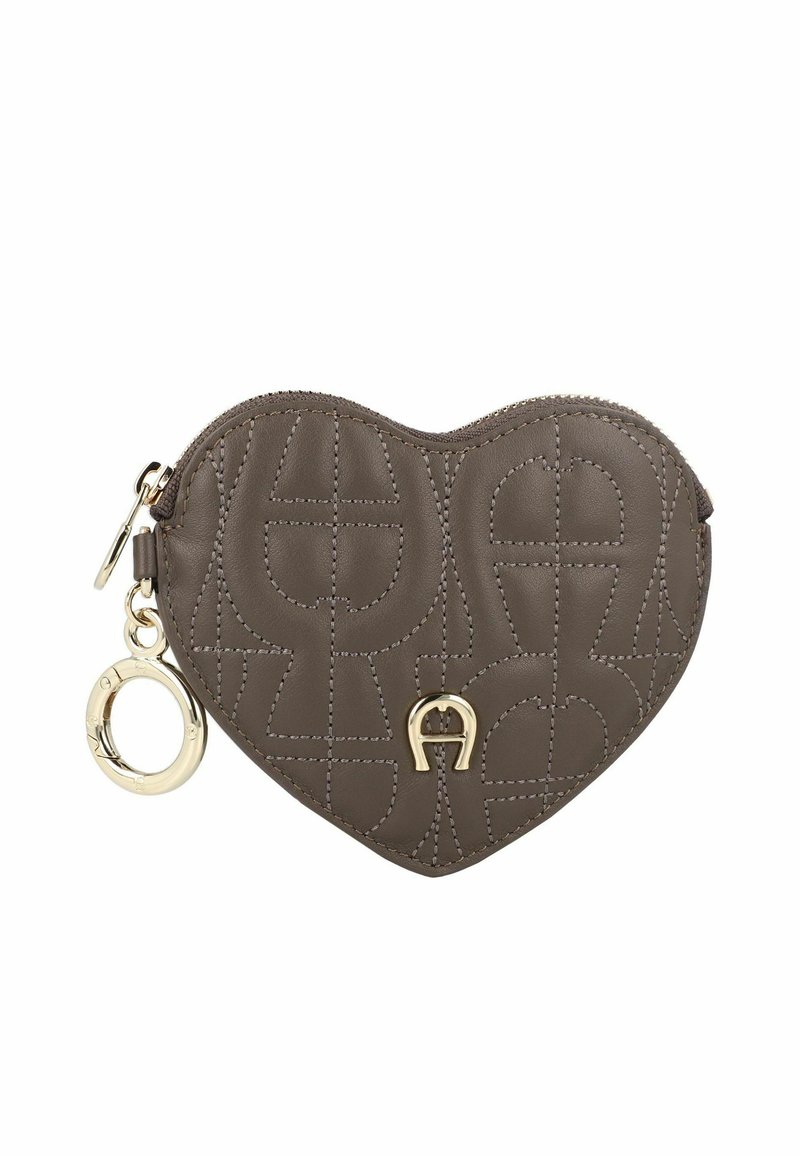 Pochette di pelle marrone a forma di cuore con motivo logo in rilievo, ferrature dorate e chiusura con cerniera. Presenta un anello decorativo portachiavi.