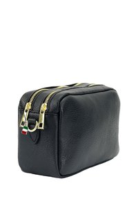 Zwarte leren cosmetica tas met een gestructureerd oppervlak, gouden ritsen en een klein Italiaans vlagdetail op de rits. Rechthoekige vorm.