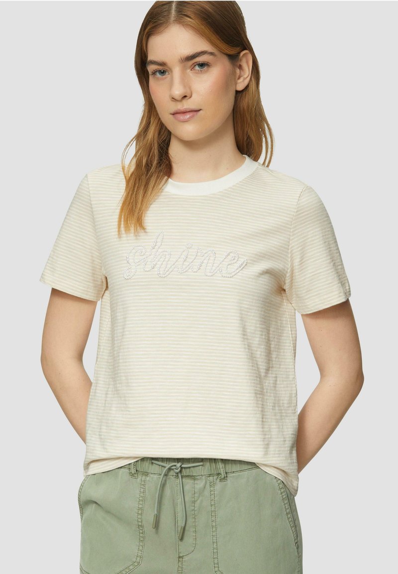 Kurzärmliges, cremefarbenes T-Shirt mit hellen Streifen und dem Wort "shine" in Silber gestickt. Der Stoff wirkt weich und hat eine lockere Passform.
