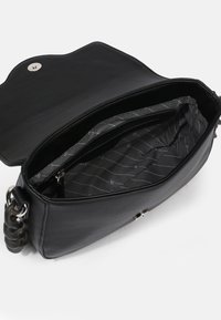 Borsa in pelle nera con un'esterno testurizzato. L'interno è foderato in tessuto grigio con un motivo sottile. Dettaglio della maniglia a catena visibile.