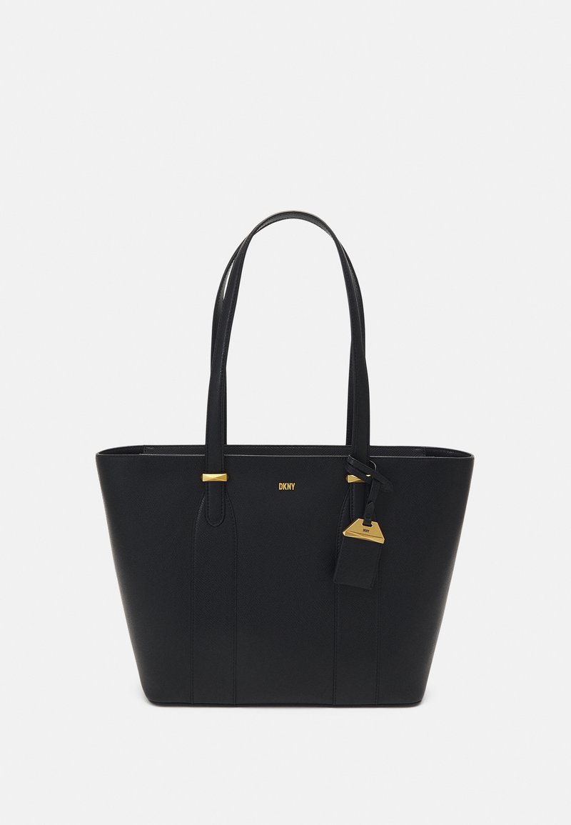 Sac cabas en cuir noir avec doubles poignées, accents dorés et logo embossé. Il présente une forme rectangulaire et une étiquette à bagages amovible.