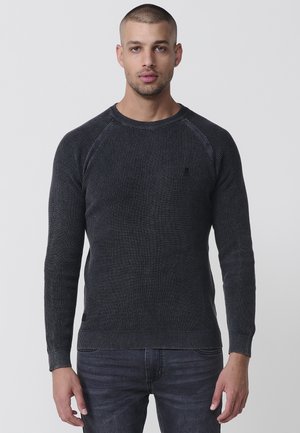 Dunkelgrauer Strickpullover mit gerippter Textur, Rundhalsausschnitt und langen Ärmeln. Verfügt über ein kleines Logo auf der Brust und eine enganliegende Silhouette.
