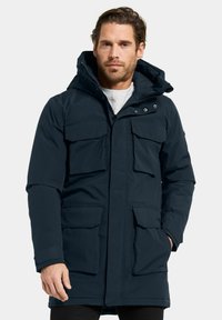 Mörkblå parkasjacka med huva, flera fickor framtill och dragkedja. Tillverkad av mjukt, väderbeständigt material.