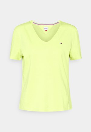 Camiseta de manga corta con cuello en V en verde lima brillante, hecha de algodón suave. Presenta un pequeño detalle de logo en el pecho izquierdo.