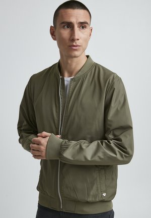 Olivegrüne Bomberjacke aus glattem, leichtem Material. Mit gerippten Bündchen und Kragen, Frontreißverschluss und Seitentaschen.