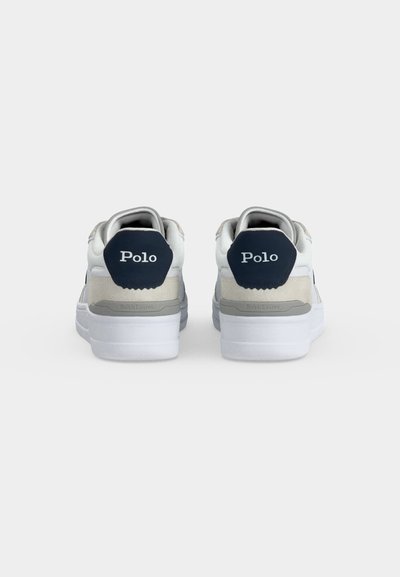 Λευκά και γκρι αθλητικά παπούτσια Polo Ralph Lauren, που φαίνονται από πίσω, με λουράκια τακουνιού σε ναυτικό μπλε χρώμα και το κείμενο "Polo".