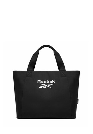 Czarna torba na ramię z podwójnymi uchwytami, z białym logo Reebok umieszczonym na środku z przodu oraz małą metką z tkaniny z boku.