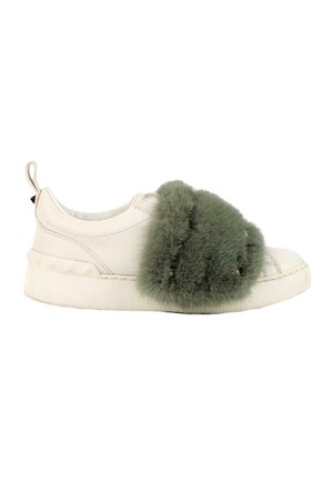Biały sneaker z grubą białą podeszwą i dużym zielonym, puszystym paskiem z futerka na górze, do dekoracji i zapięcia.