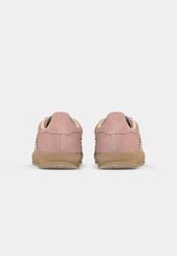 Roze suède sneakers met geperforeerde zijkanten, beige accenten en gumrubberen buitenzolen. Geronde vorm en gevoerde kraag.