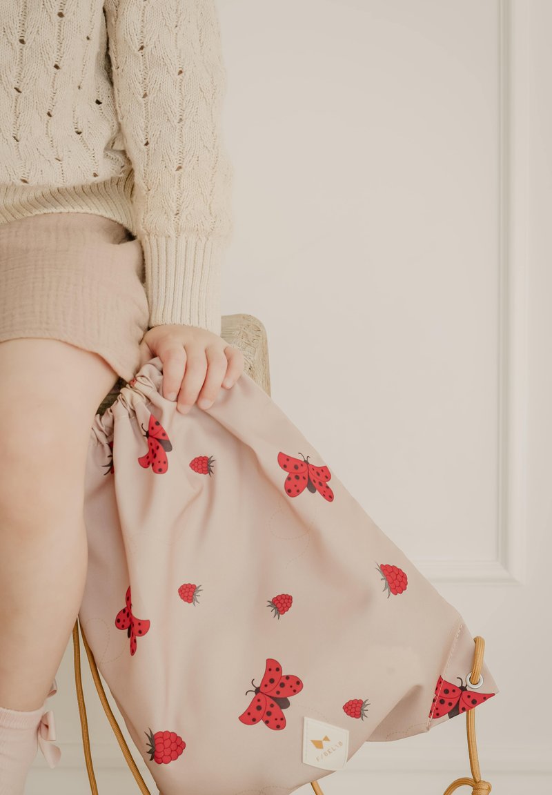 Rosa snorpose med røde sommerfugle- og hindbærmønstre, lavet af blødt stof. Inkluderer et lille logo mærkat på siden.