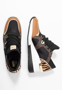 Czarne i brązowe sneakersy z mieszanką materiałów, z teksturowanym bocznym panelem, złotymi akcentami i masywną białą podeszwą. Stylowy detal w zwierzęcy wzór.