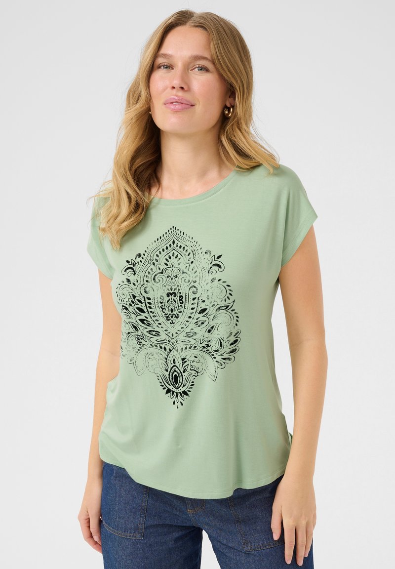 T-shirt vert clair à manches courtes, col rond, présentant un motif paisley noir sur le devant. Tissu doux et respirant.