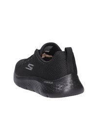 Scarpa atletica nera in rete con suola in gomma testurizzata, tallone imbottito e accento con logo. Design leggero e slip-on per una facile calzata.