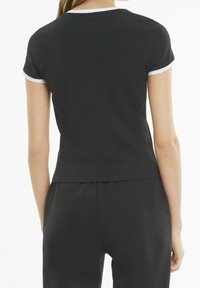 Czarna bluzka z krótkim rękawem z białym lamówką przy kołnierzu. Miękki, gładki materiał i dopasowany krój; z tyłu lekko zaokrąglony dół.