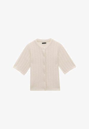 Krótki sweter z krótkim rękawem w jasnej kremowej kolorystyce, o dzianinowej fakturze z wzorem w warkocze, z okrągłym dekoltem i guziczkami przypominającymi perły z przodu.