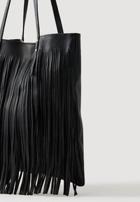 Bolso tote de cuero negro con detalles de flecos verticales largos. Presenta dos asas de hombro y una textura suave. Sin cierres visibles.