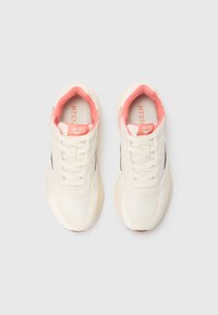 Hvite sportssko med mesh-overdel, rosa detaljer på kragen, og en kraftig beige såle. Har snøring og en blå stripe på siden.