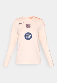 Világos rózsaszín, hosszú ujjú FC Barcelona futballmez sötétkék Nike és Spotify logókkal a mellkason, valamint narancssárga csíkkal a vállon.